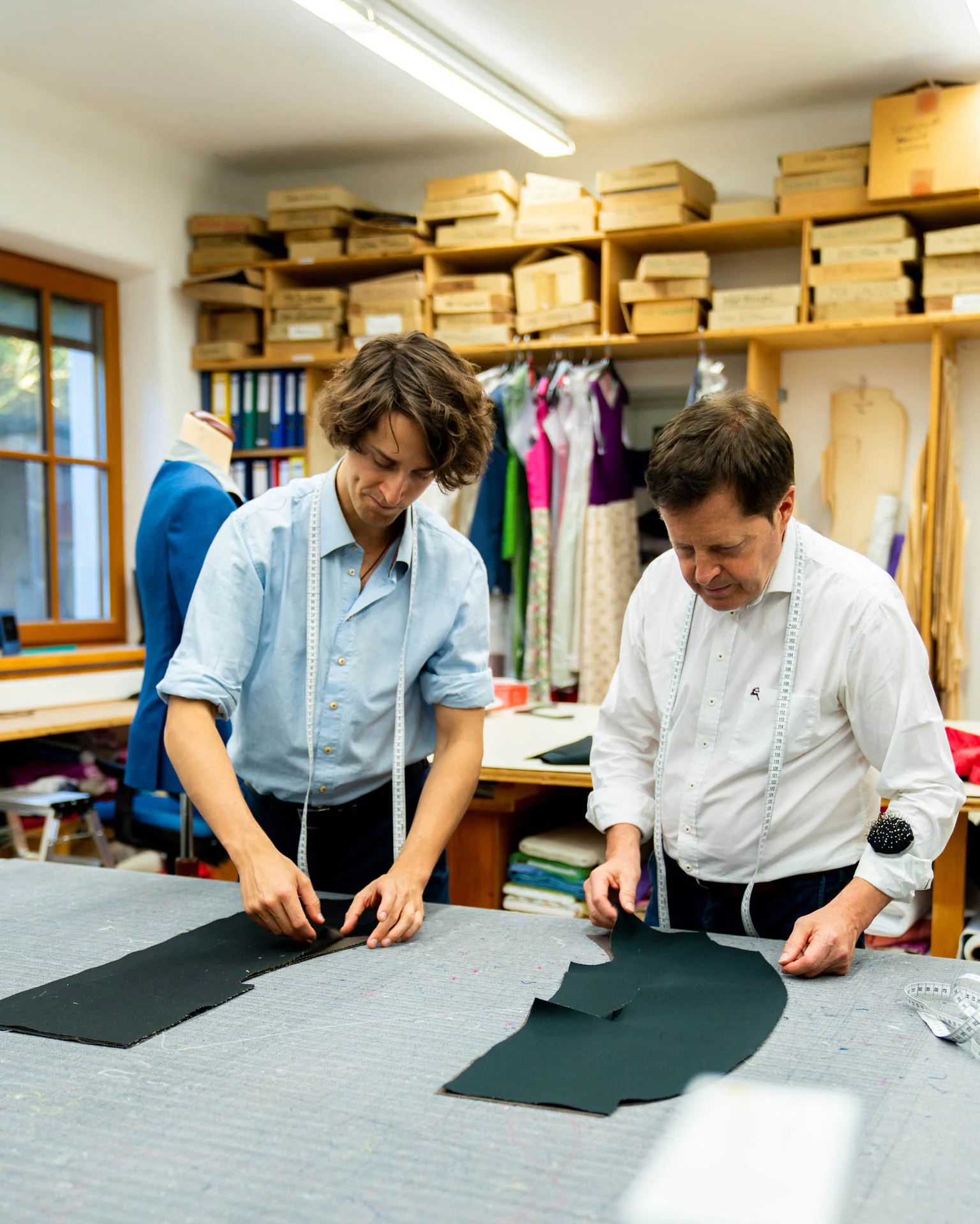 Stefan Wimmer und ein Kollege prüfen zugeschnittene Stoffteile im Atelier